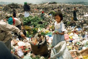 A Filipino girl inspects the contents of a small bag scavenged from one of thousands of bags of garbage at the Payatas dump Tuesday, July 10, 2001 in Quezon City. Thousands of the poorest Filipinos still scavenge for a living at the Payatas dump despite the fact that a garbage slide which killed hundreds of people one year ago could happen again on the unstable mountain of garbage. (AP Photo/Ed Wray)